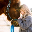 Kind kuschelt mit deutschem Reitpony, eine der beliebtesten Pferderassen 2023